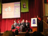 Libby speaking & Freya seated on stage